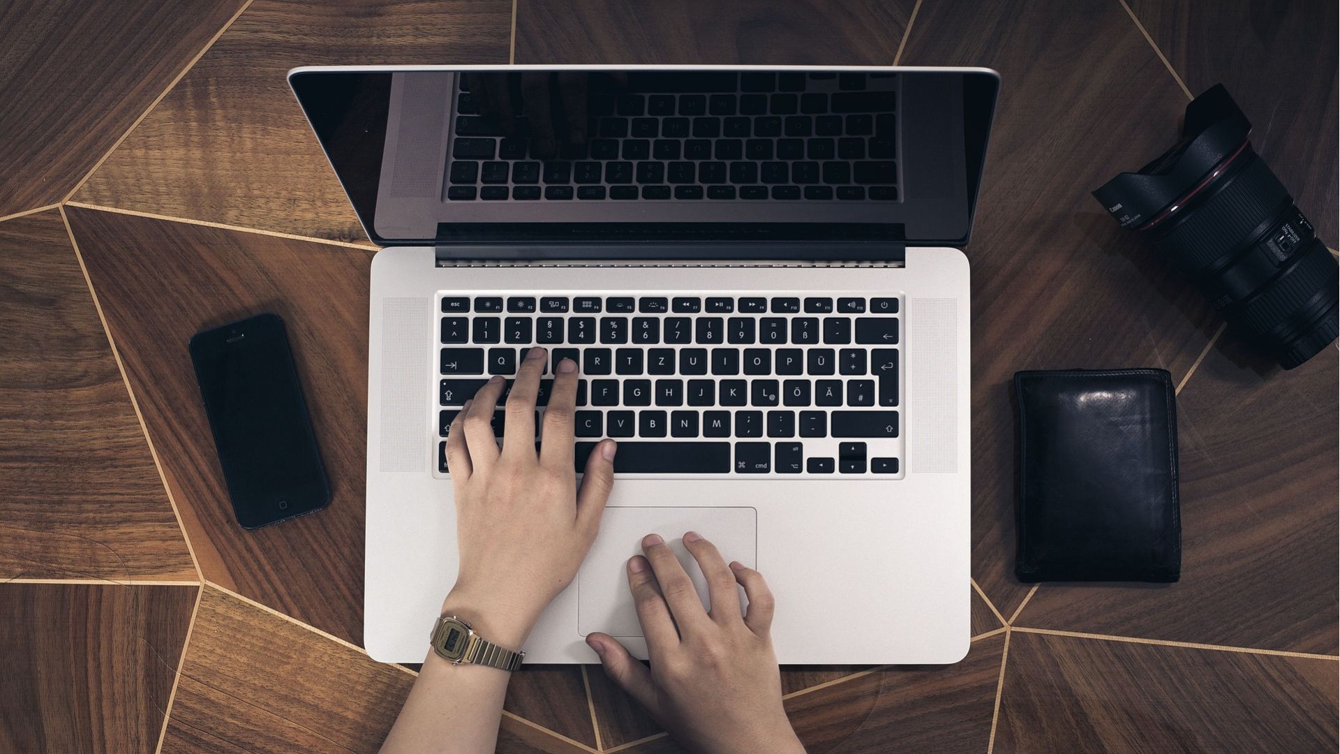 Hands Writing on a Laptop over a table.